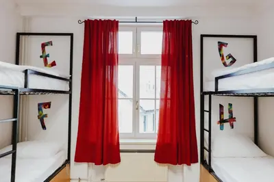 a room with four bunk beds and a window at Party Hostel Zzz in Ljubljana