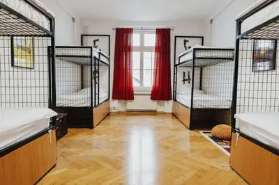 a room with four bunk beds with red curtains at Party Hostel Zzz in Ljubljana