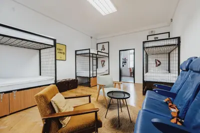 a living room with a blue couch and chairs at Party Hostel Zzz in Ljubljana