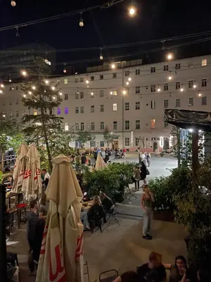 a group of people standing around a building at night at Party Hostel Zzz in Ljubljana