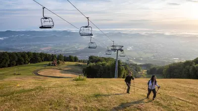 two people standing on a hill with a ski lift at Pohorje Fox duplex apartment in Maribor