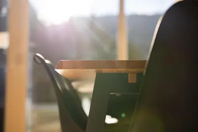 a chair with a wooden table in a room at Pohorje Fox duplex apartment in Maribor