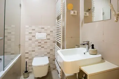 a white bathroom with a sink and a toilet at Pohorje Fox duplex apartment in Maribor