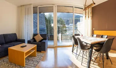 a living room with a table and chairs and a couch at Pohorje Fox duplex apartment in Maribor