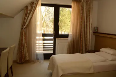 a bedroom with a bed and a large window at Vila Park B&B - Adults Only in Bohinj