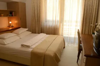 a hotel room with a bed and a desk and a window at Vila Park B&B - Adults Only in Bohinj