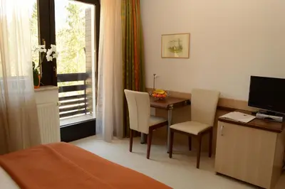 a room with a desk and a table with chairs and a window at Vila Park B&B - Adults Only in Bohinj