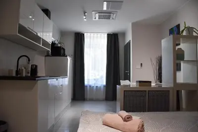 a bedroom with a bed and a kitchen with a window at Apartma Darsi in Ajdovščina
