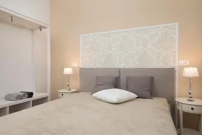 a bedroom with a bed with two tables and two lamps at Cozy apartments in Ljubljana