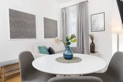 a white living room with a white table and chairs at Cozy apartments in Ljubljana