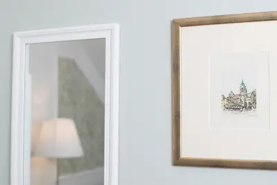 a framed picture on a wall next to a lamp at Cozy apartments in Ljubljana