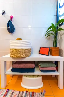 a shelf in a bathroom with towels and a plant at Boho House 4 camp Terme Catez with promotional tickets prices in Čatež ob Savi
