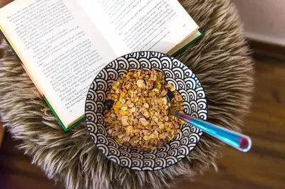 a bowl of cereal and a book next to a book at Boho House 4 camp Terme Catez with promotional tickets prices in Čatež ob Savi