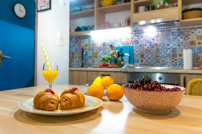 a table with a plate of pastries and a bowl of fruit at Boho House 4 camp Terme Catez with promotional tickets prices in Čatež ob Savi