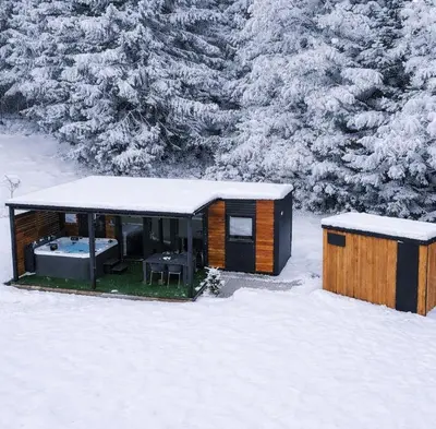a small cabin in the snow with snow covered trees at Resort na jasi in Zreče