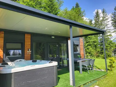 a house with a hot tub in the yard at Resort na jasi in Zreče