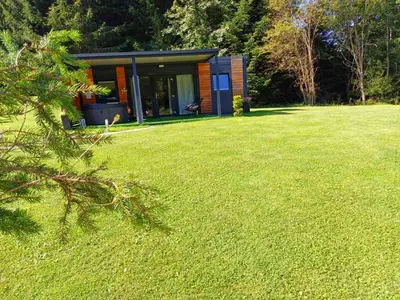 a small cabin in the middle of a grass field at Resort na jasi in Zreče