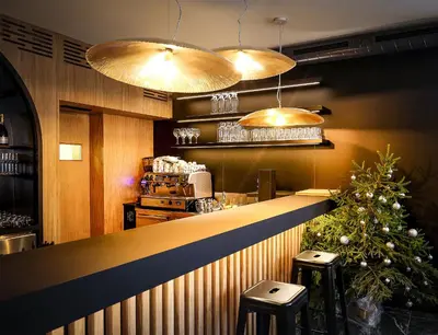 a bar in a restaurant with a christmas tree at Hotel Pino Alpino in Kranjska Gora