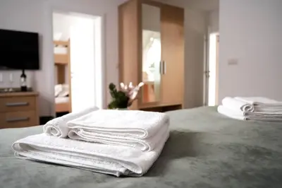 a pile of towels sitting on top of a bed at Hotel Pino Alpino in Kranjska Gora
