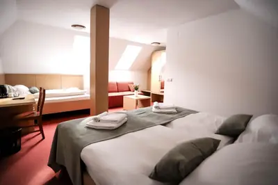 a bedroom with a bed with towels on top of it at Hotel Pino Alpino in Kranjska Gora