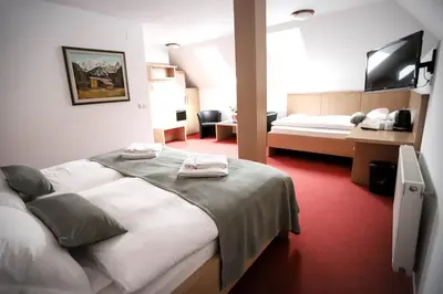 a hotel room with two beds and a television at Hotel Pino Alpino in Kranjska Gora
