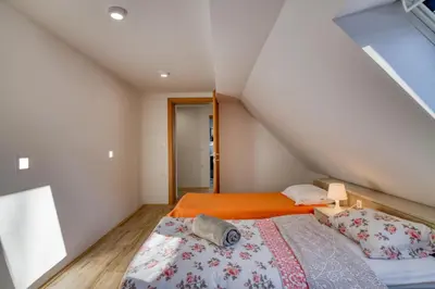 a bedroom with an orange bed in a attic at Farmhouse Raspberry Pool&Wellness - Happy Rentals in Vransko
