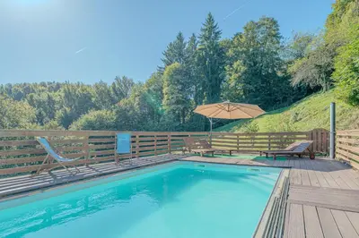 a swimming pool with two chairs and an umbrella at Farmhouse Raspberry Pool&Wellness - Happy Rentals in Vransko