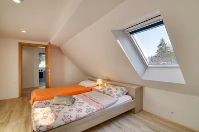 an attic bedroom with a bed and a window at Farmhouse Raspberry Pool&Wellness - Happy Rentals in Vransko
