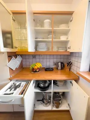 a kitchen with white cabinets and white dishes in it at Spa House Blue Lagoon in Terme Čatež in Čatež ob Savi