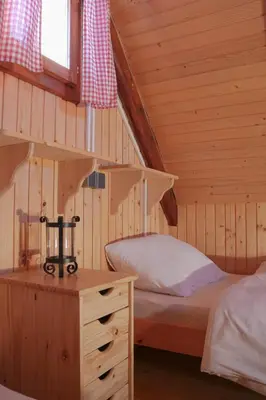 a bedroom with a bed in a wooden cabin at Chalet Kočna - I FEEL ALPS in Stahovica