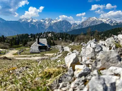 a glass house on a hill with mountains in the background at Chalet Kočna - I FEEL ALPS in Stahovica