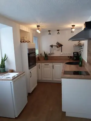 a kitchen with white cabinets and a white refrigerator at Apartment by Tanja&Nejc in Bled