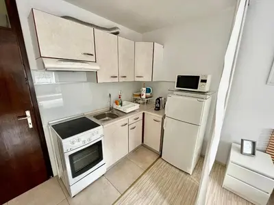 a small kitchen with a white stove and refrigerator at Apartment TiSa, Bovec in Bovec