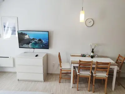 a dining room with a table and a tv on the wall at Apartment TiSa, Bovec in Bovec