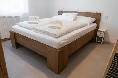 a large bed with white sheets and pillows on it at Apartma BoLeRo in Tolmin