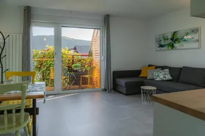 a living room with a couch and a balcony at Apartma BoLeRo in Tolmin