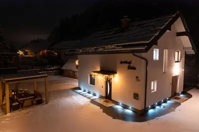 a small building with lights on it at night at Apartmaji ENIA Rateče-Planica, Kranjska Gora in Kranjska Gora