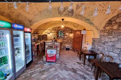 a room with a restaurant with tables and a refrigerator at Krka River Lodge in Krka