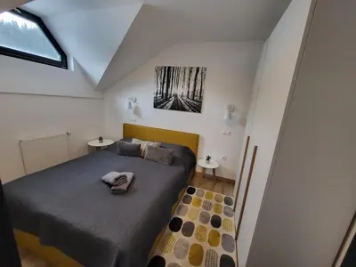 a small bedroom with a bed and two tables at Apartma A1 GOLTE in Mozirska Koča