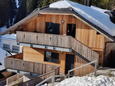 a log cabin in the snow with two decks at Apartma A1 GOLTE in Mozirska Koča