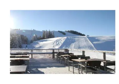 a group of tables and chairs in the snow at Apartma A1 GOLTE in Mozirska Koča