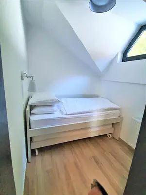 a small bedroom with a bed in a attic at Apartma A1 GOLTE in Mozirska Koča