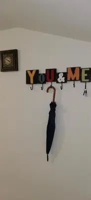 a black umbrella hanging on a wall with a shelf at Apartma Regina in Slovenj Gradec