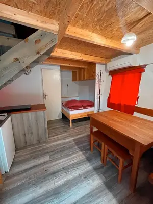 a room with a wooden table and a bed at Koča Janka in Metke in Velika Loka