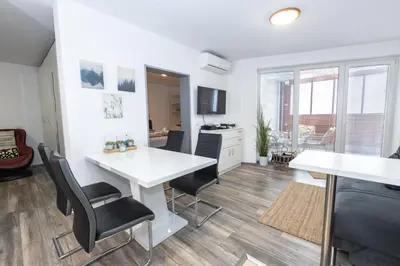 a kitchen and living room with a white table and chairs at Rakita Premium Family Suite in Moravske Toplice