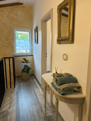 a room with a table with a mirror on the wall at Hisa STERNA - WELL HOUSE in Zgornje Škofije