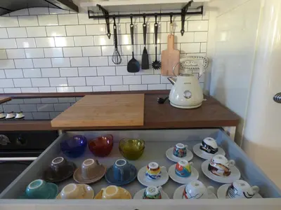 a tray filled with cups and saucers in a kitchen at Hisa STERNA - WELL HOUSE in Zgornje Škofije