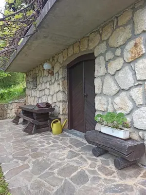 a stone building with a wooden door and a table at Serenity in Dramlje