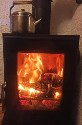 a fire in a fireplace with a pot on top at Serenity in Dramlje