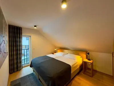 a bedroom with a large bed and a window at Apartmaji Kotnik in Kranjska Gora